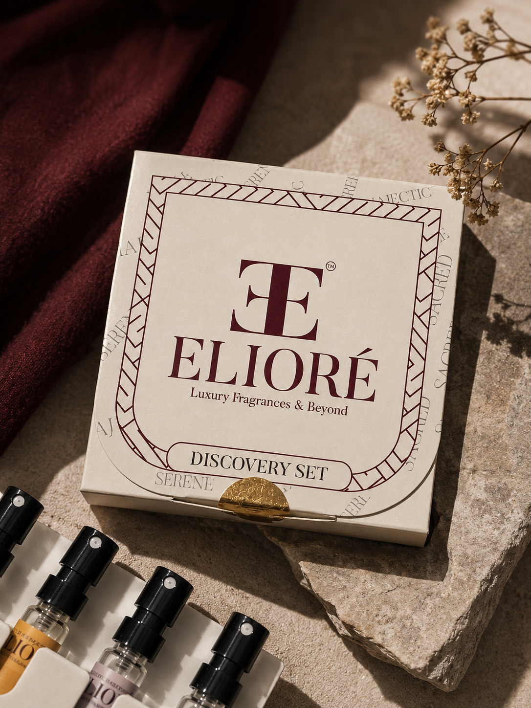 Elioré perfume discovery set on a stone surface with dried flowers.