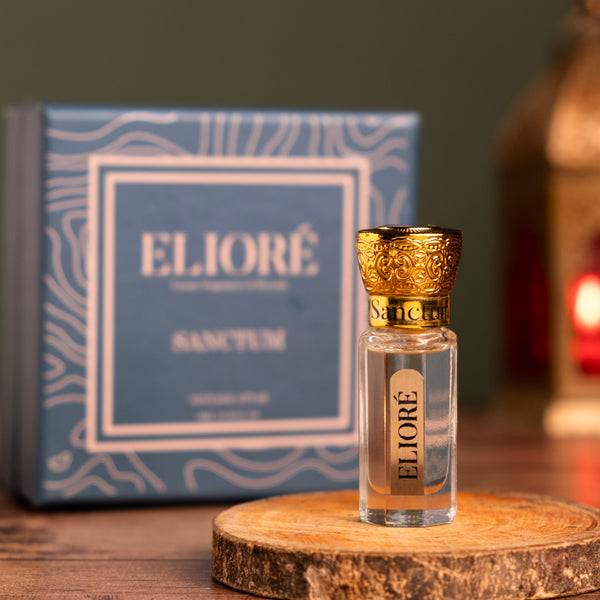 Eliore perfume bottle with gold cap on a wooden stand, box in the background