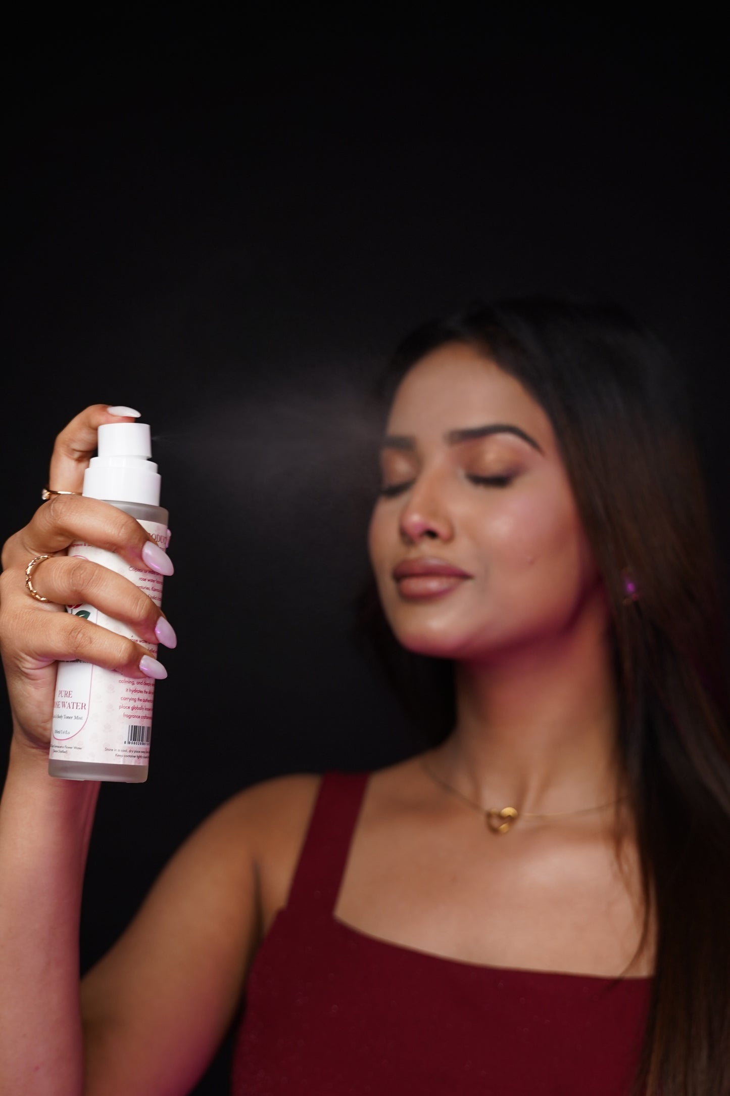 Woman applying eliore pure rose water face mist