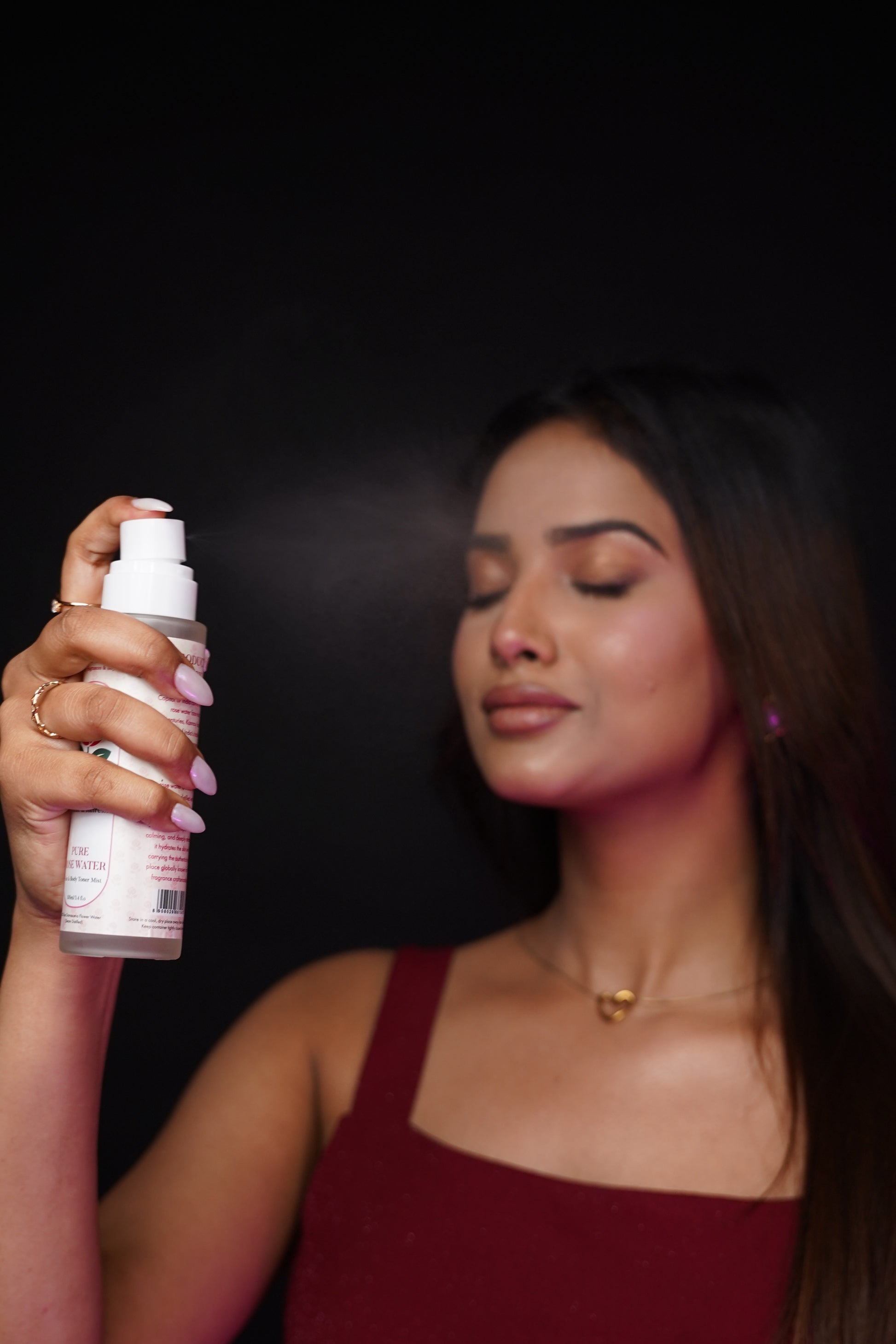 Woman applying eliore pure rose water face mist