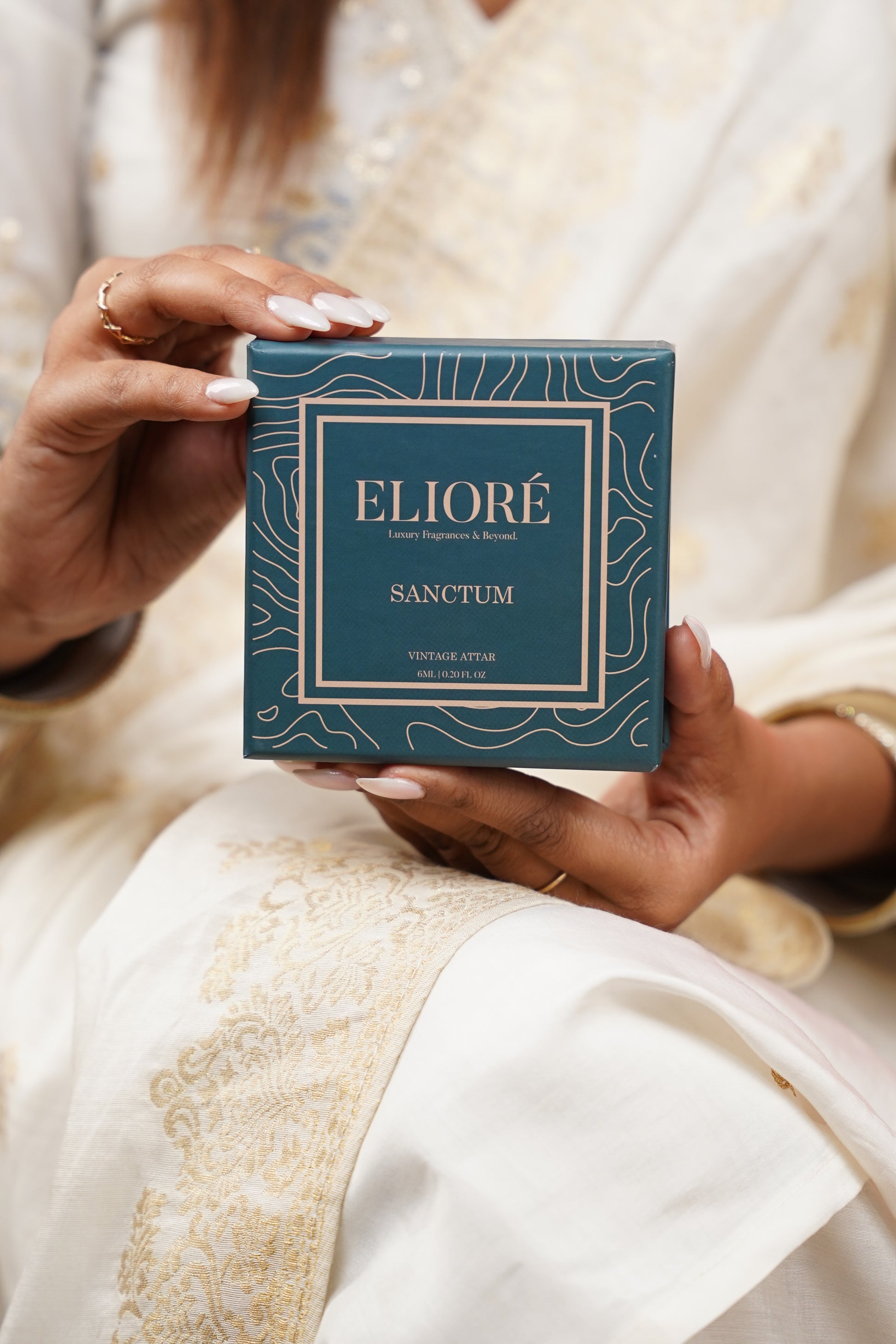 Person holding a blue box with 'Eliore' branding against a blurred background