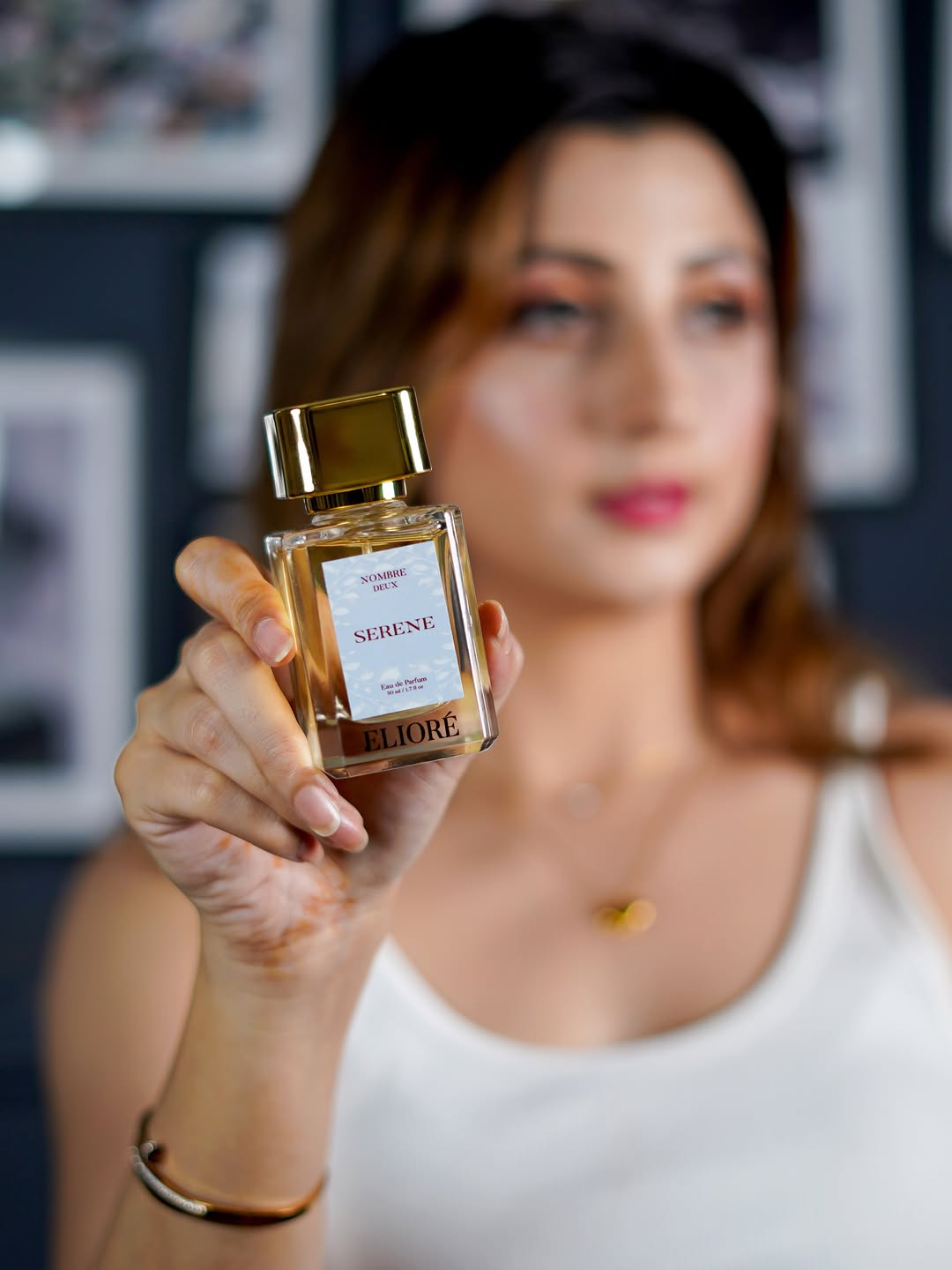 Woman holding a perfume bottle with a blurred background